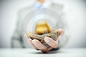 Retirement savings golden nest egg in businessman hand