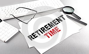 RETIREMENT TIME text on a paper with keyboard, calculator on grey background