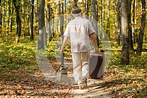 Retirement travel and hobbies. Always have bag ready to go. Elderly carry travel bag. Old man travel with retro bag