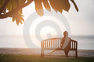 Retirement Vacation Concept. women retired sitting alone on chair that have the sea background.