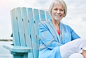 Retirement was made to rest and relax. Portrait of a happy senior woman relaxing on a chair outside.