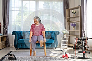 Retirement woman raising leg to exercise at home