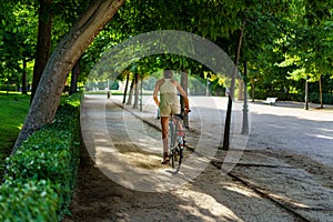 Retiro Park in Madrid on a summer day at sunrise with people doing sports on bicycles,