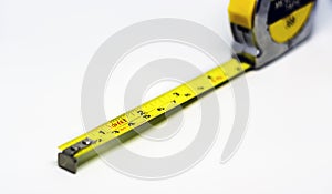 Retractable yellow metal measuring tape. Measurements expressed in centimeters and feet