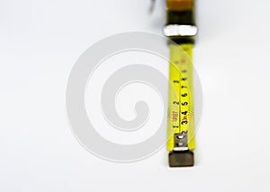 Retractable yellow metal measuring tape. Measurements expressed in centimeters and feet