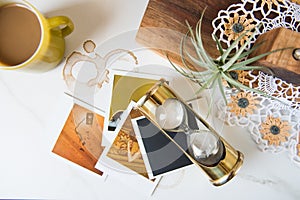Retro 1970s Themed Still Life with Brass Hourglass Polaroids and Pyrex mug