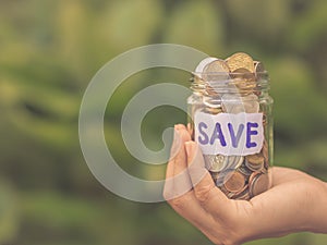 Retro abstract money saving women hand holding glass jar coins