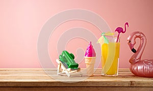 Retro aesthetic still life with orange juice, flamingo pool float and plastic toys, Summer vacation vibes concept over pink
