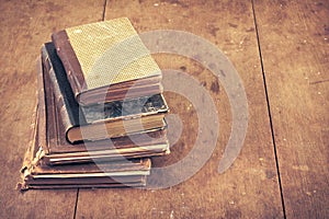Retro aged books on oak wooden table. Vintage style filtered photo