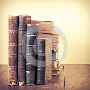 Retro aged books on oak wooden table. Vintage style filtered photo