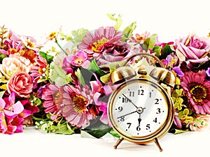 Retro alarm clock with flowers on white background