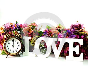 Retro alarm clock and love with flowers on white background