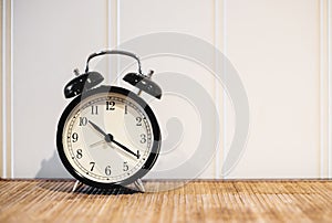 Retro alarm clock with 10 O`clock and twenty minuet, on wooden table and white background with copy space photo