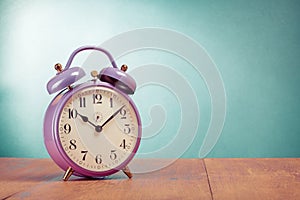 Retro alarm clock on oak table front mint green background