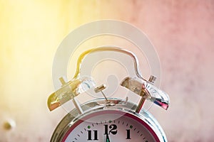 Retro alarm clock on a red white background close-up, toning