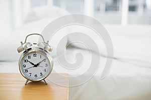 Retro alarm clock standing on a bedside table