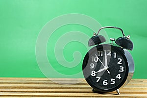 Retro alarm clock on table on mint green background