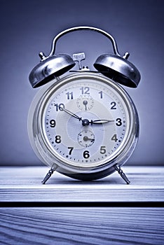 Retro alarm clock on wooden table