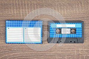 Retro audio cassette and blue case with striped paper to write text.