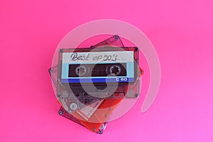 Retro audio cassette tape from the 80s and 90s on a red background.