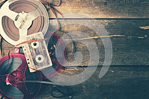 Retro audio reels and cassette on wooden table with copy space