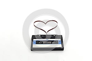 Retro audio stereo mono blue cassete with magnetic tape in shape of heart.