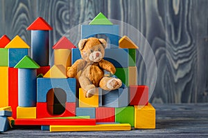 Retro Bear toy alone on wooden floor with bilding blocks photo