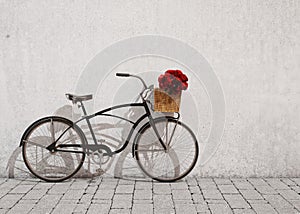 Retro bicycle with basket and flowers in front of the old wall, background