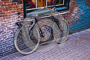 Retro bike parked against a brick wall.