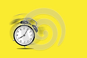 Retro black alarm clock alerting at seven o`clock on yellow background.