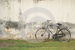 Retro Black Bicycle against Old Plastered Wall