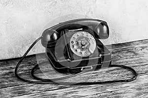 Retro black rotary telephone on wooden table