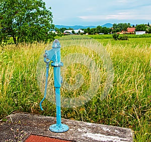 Retro čerpadlo do vrtu za slunečného dne, staré ruční vodní čerpadlo (pákové čerpadlo).