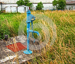 Retro borehole pump on a sunny day, old manual water pump (lever pump).