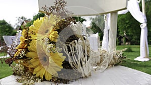 Retro bouquet of yellow  Gerber daisy on a white chair at the wedding