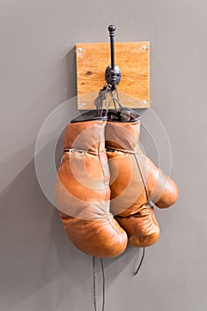 Retro boxing gloves. vintage sport equipment. boxing concept. old boxing gloves on hanger. history of sport. worn gloves