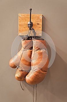 Retro boxing gloves. vintage sport equipment. boxing concept. old boxing gloves on hanger. history of sport. worn gloves