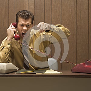 Retro business scene of angry man at desk.