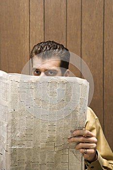 Retro businessman peeking over newspaper.
