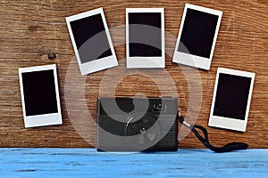 Retro camera and blank instant photos on a wooden surface