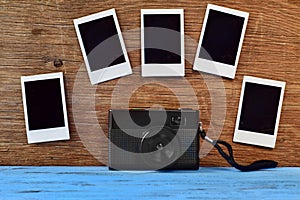 Retro camera and blank instant photos on a wooden surface photo