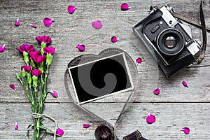 Retro camera and blank photo frame in heart shaped film with flowers