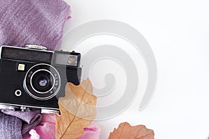 Retro camera and empty old instant paper photo album on wood table with maple leaves in autumn border design - concept