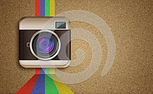 Retro camera icon with rainbow colors on corkboard