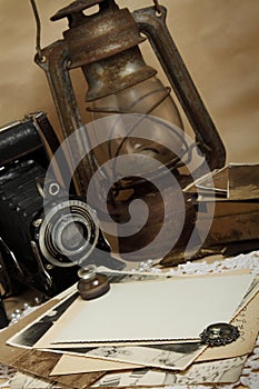 Retro camera, kerosene lamp and old photos