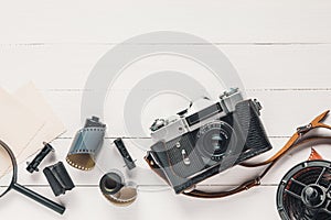 Retro camera, old photo film rolls, empty photos and magnifier