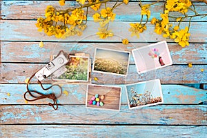 Retro camera and paper photo album on wood table with flowers border design