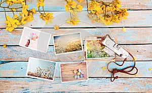 Retro camera and paper photo album on wood table with flowers border design -