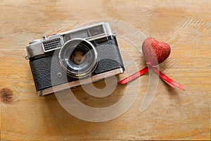 Retro Camera with red hearts on a wooden