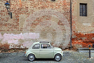 Retro car in front of ancient wall.